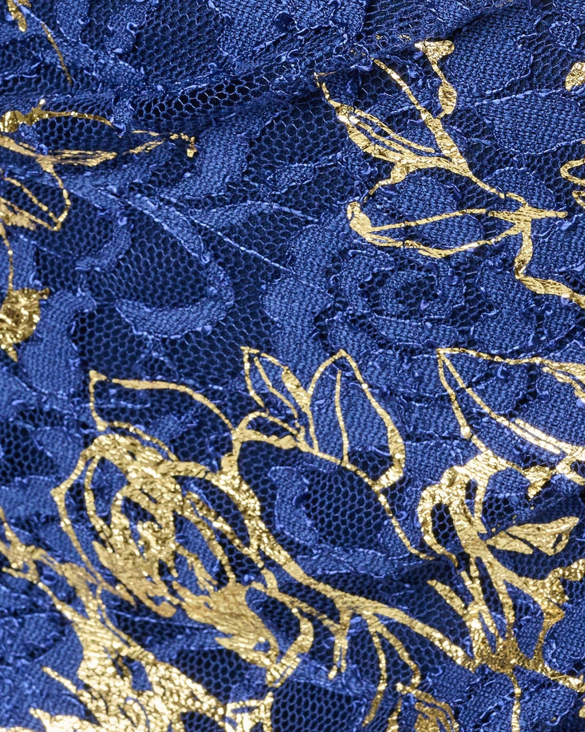 Close-up of blue textured fabric with gold floral lace embroidery