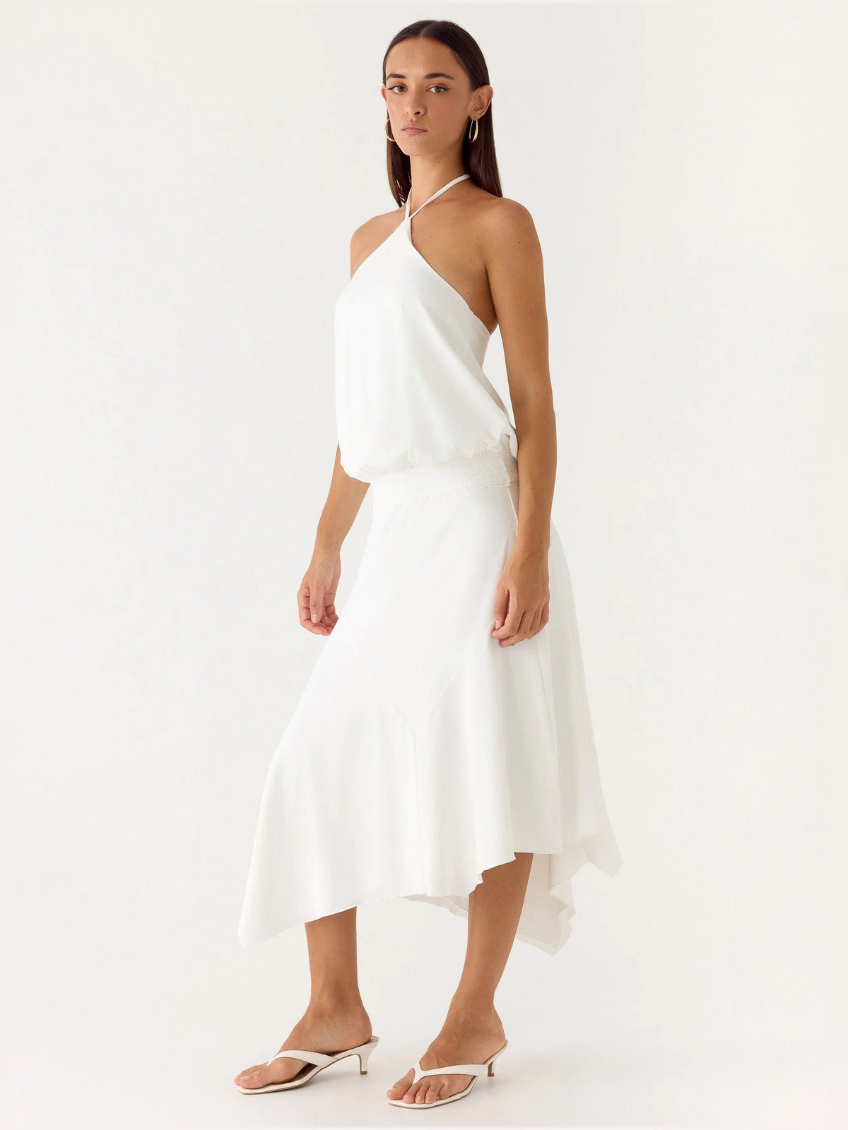 White midi formal dress with halter neckline, fitted waist, flowing asym hem