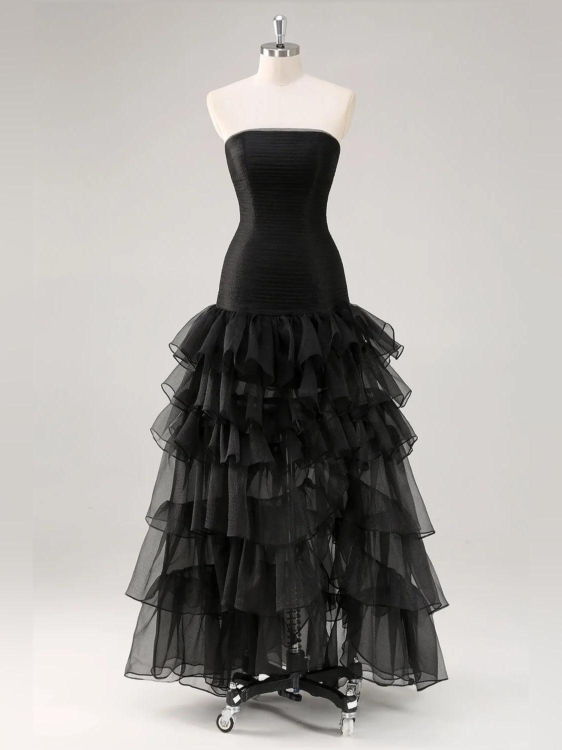 Black strapless dress on mannequin with ruched bodice and layered tulle ruffles