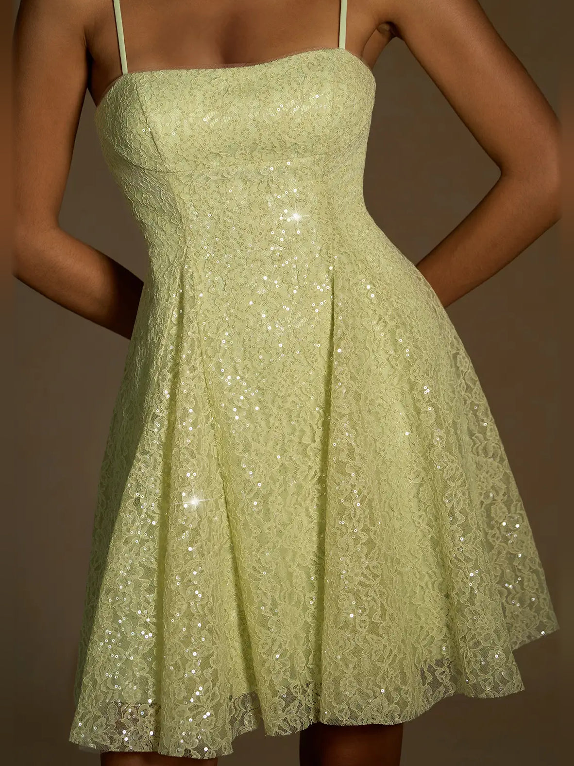 Close-up of sage green sequin A-line mini dress bodice with thin straps