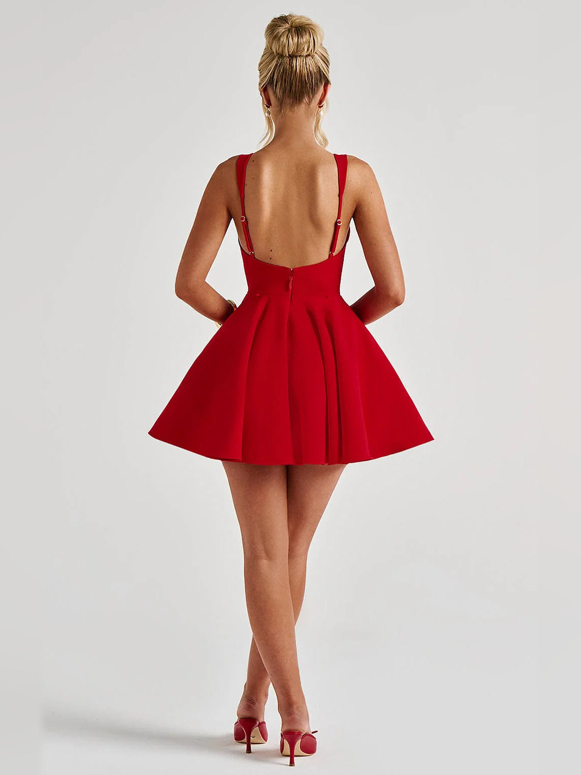 Back view of red sleeveless mini dress with open square back and short flared hem