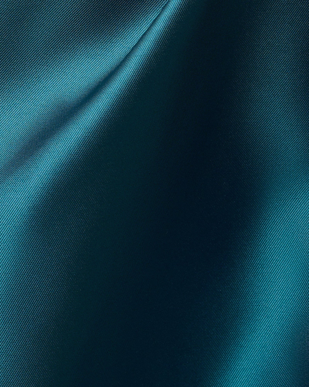 Teal satin-like fabric close-up with fine woven texture and sheen.
