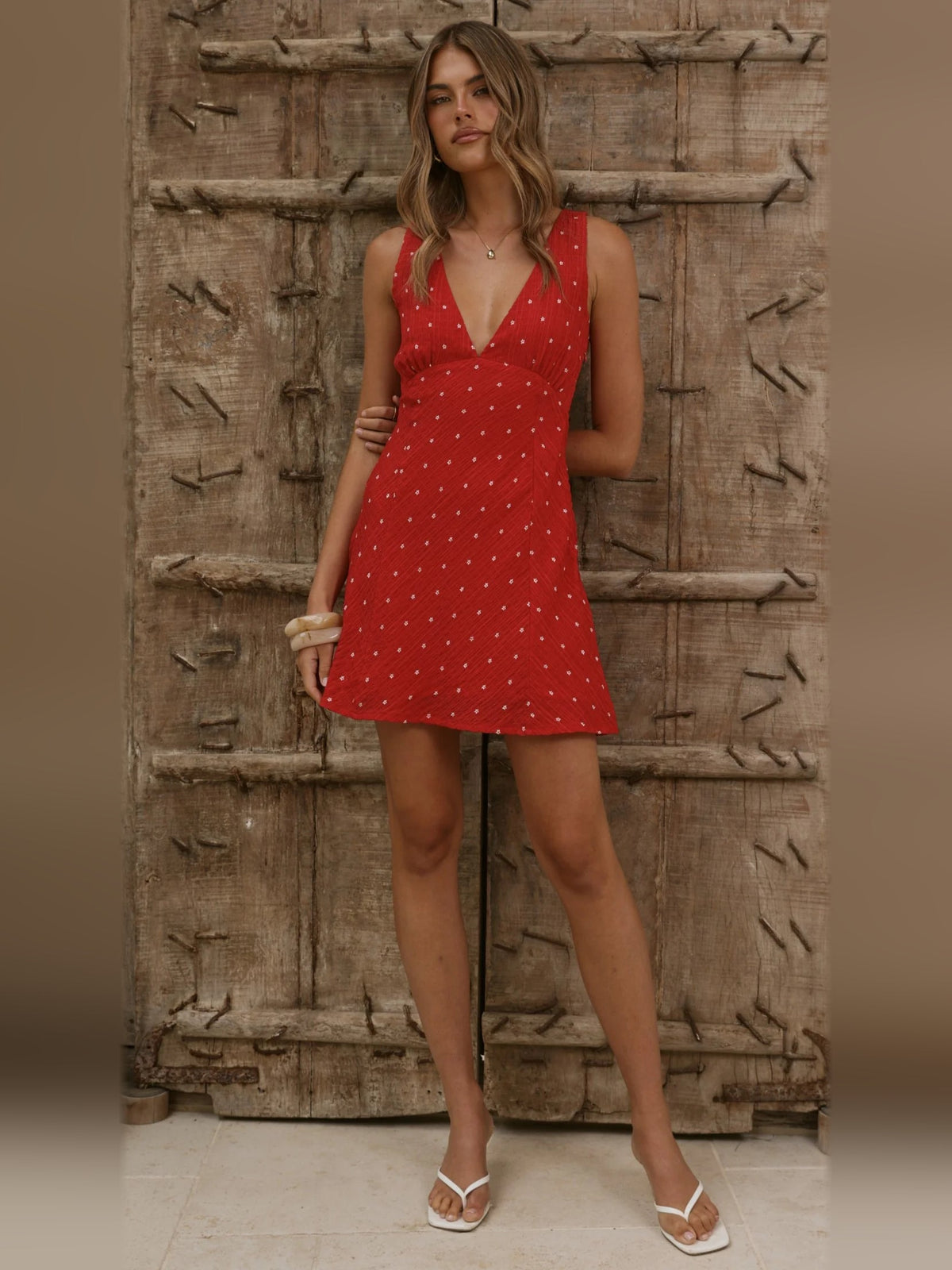 Full-length view of red sleeveless mini dress with V-neck and small white dot pattern
