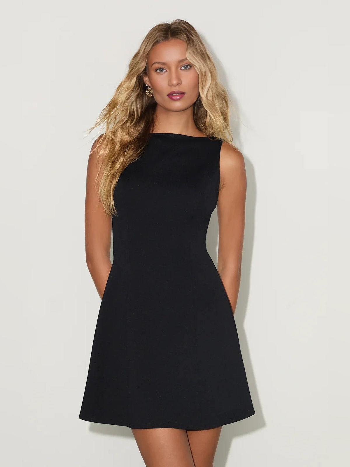 Black sleeveless boat-neck A-line mini dress with clean neckline and flared skirt