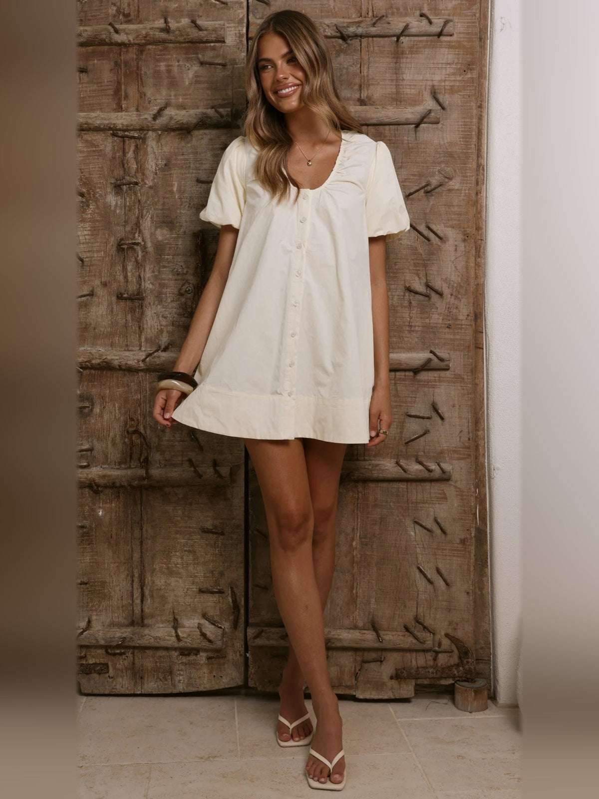 Butter button-front mini dress with short puff sleeves and scoop neckline, standing