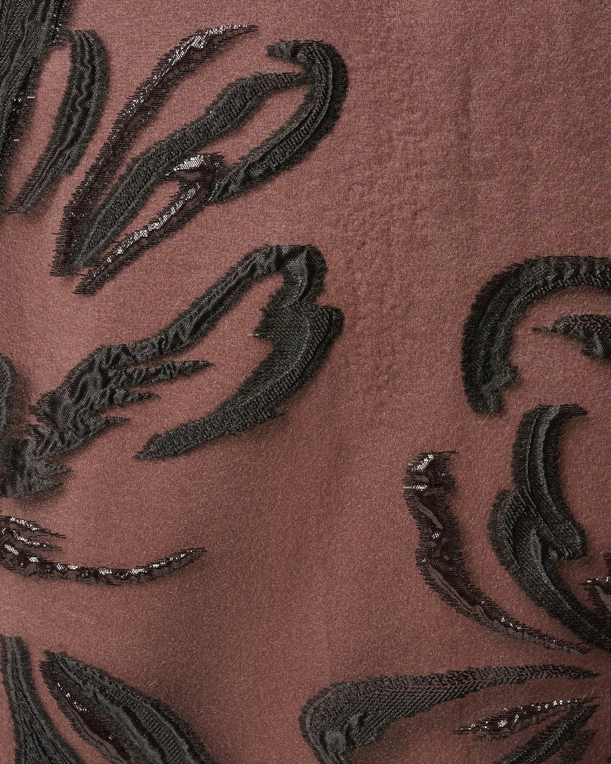 Black sheer fabric with dark floral embroidery swirls and textured embellishments