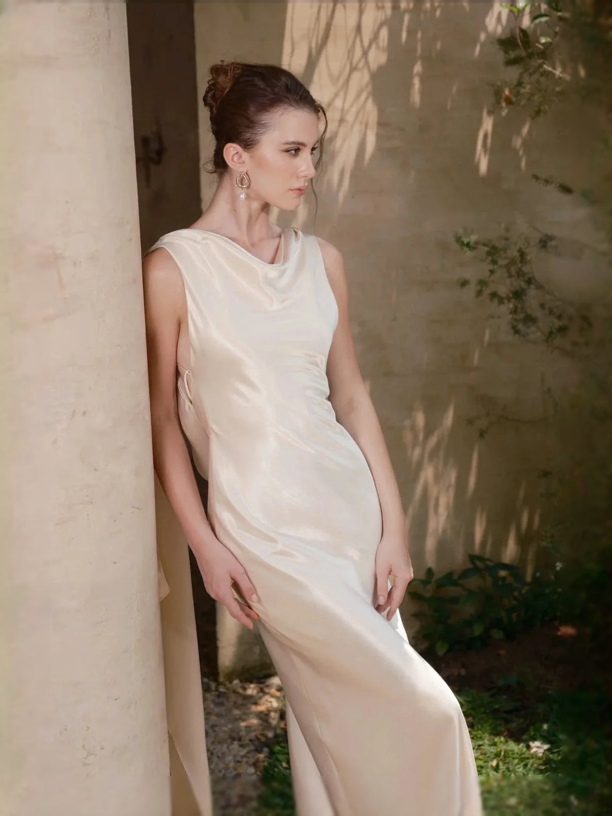 Ivory satin sheath wedding dress with cowl neckline, open back, and close-fitting skirt