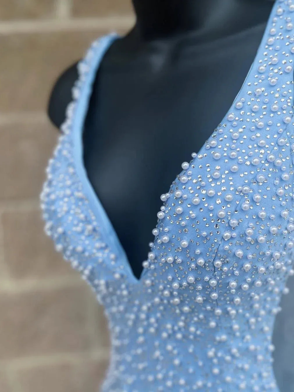 Close-up of light blue beaded V-neck mini dress, sleeveless