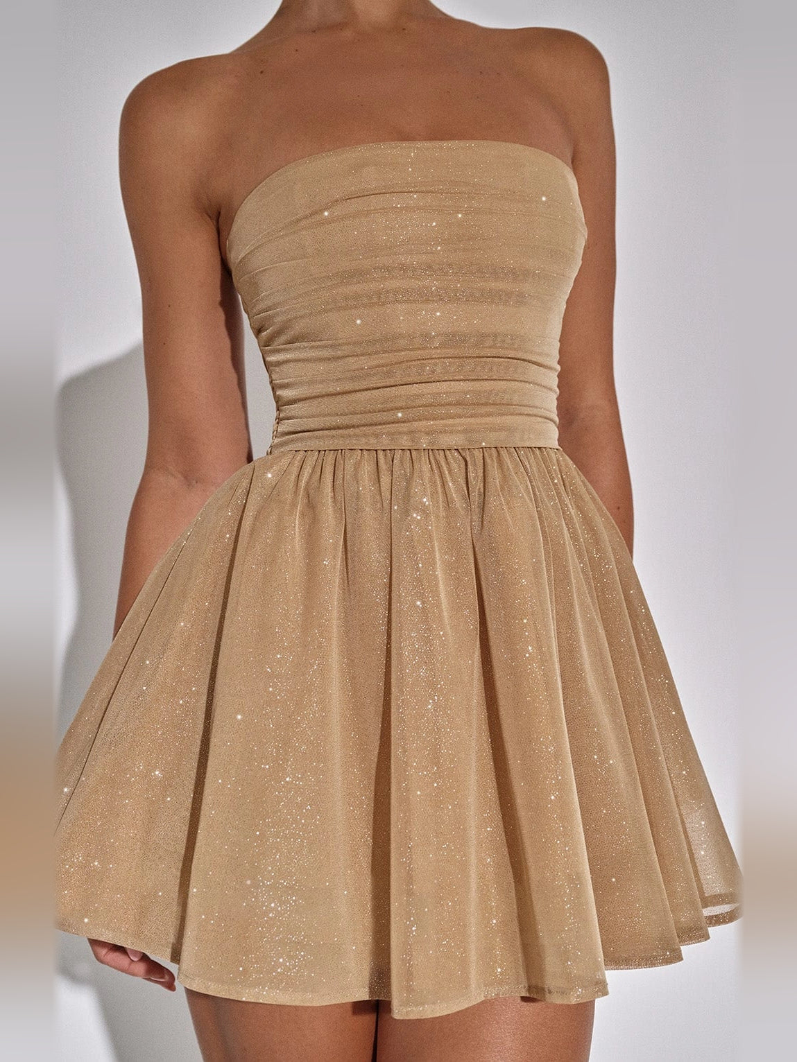 Mocha gold strapless mini dress close-up: ruched bodice with sparkly tulle skirt