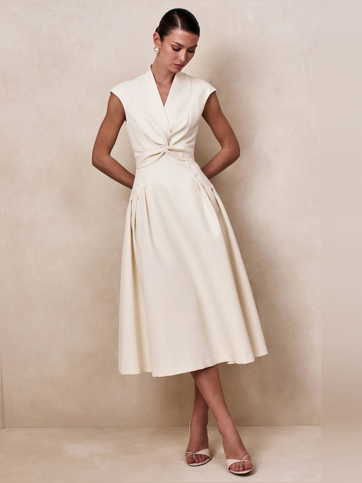Cream V-neck sleeveless midi dress with knot-tie waist and wide skirt