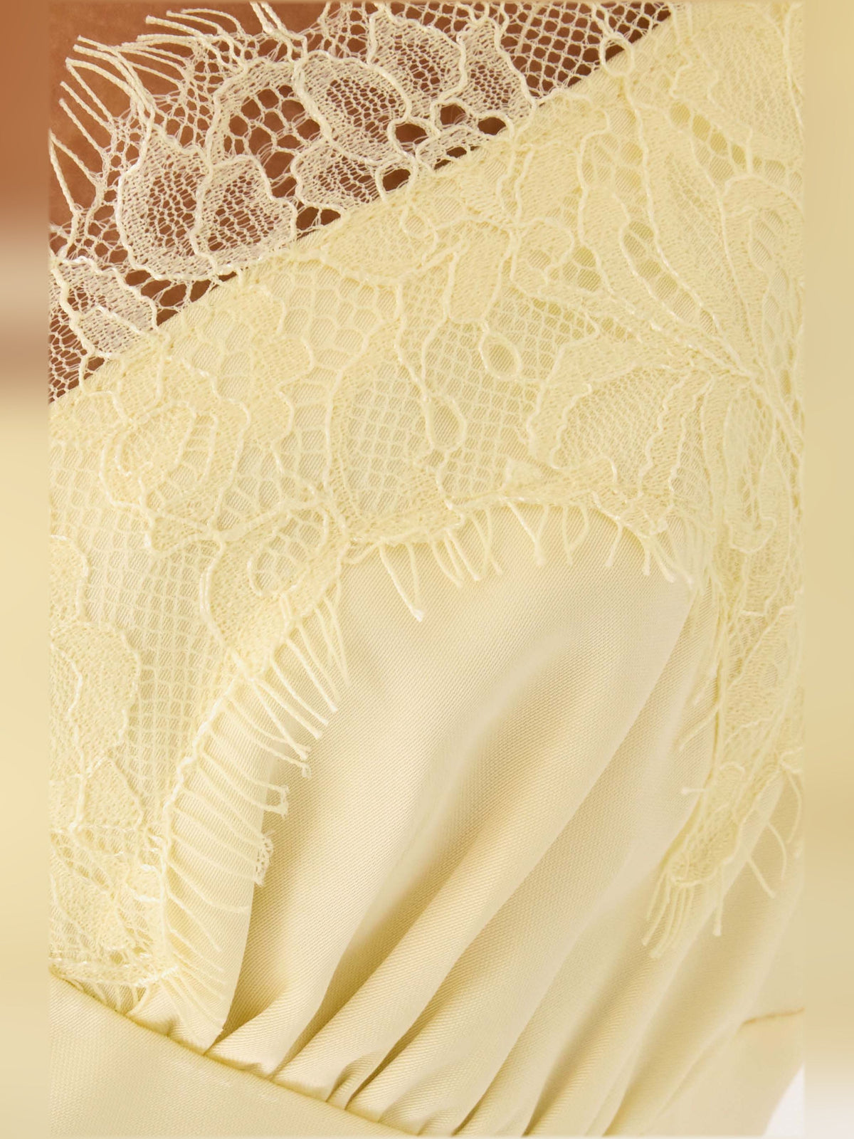 Yellow lace bodice detail with scalloped trim and soft draped overlay