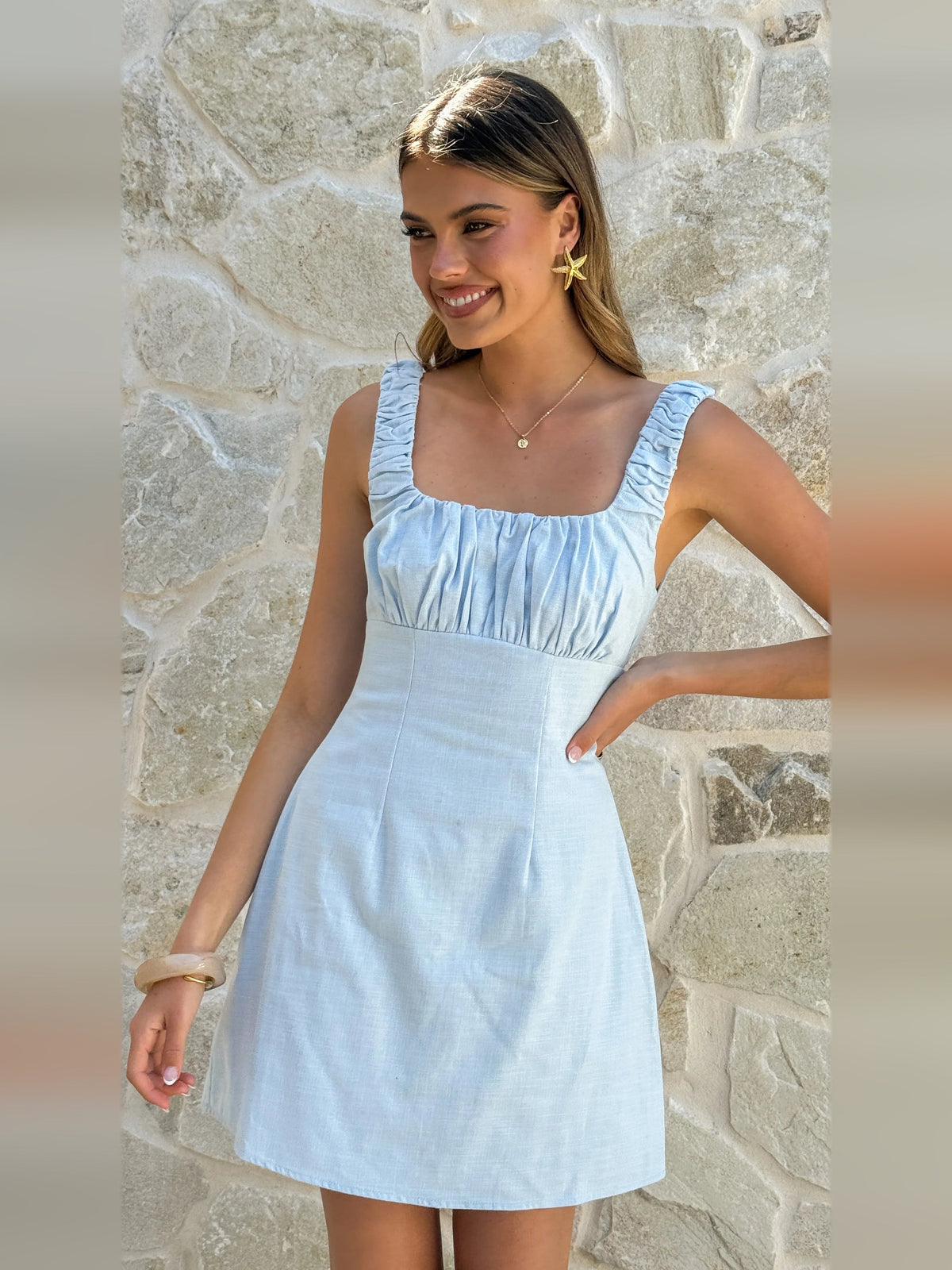 Light blue mini homecoming dress close-up with ruched square neckline and puff straps