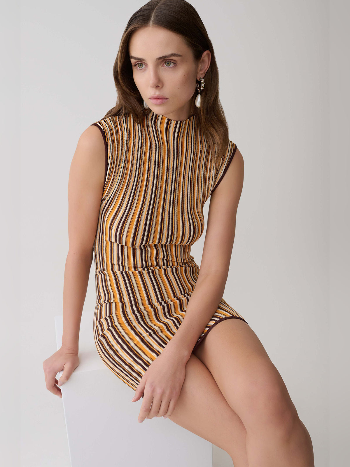 Sleeveless mini dress close-up, mock neck and fitted waist with vertical stripe pattern