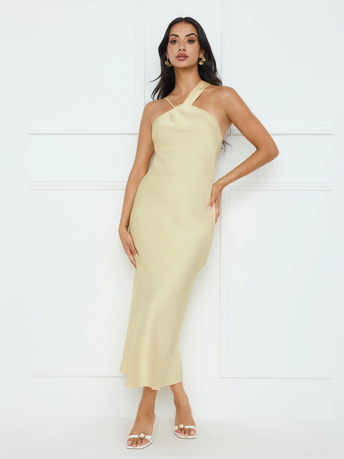 Pale yellow satin midi dress with halter neckline, fitted waist, and slim skirt