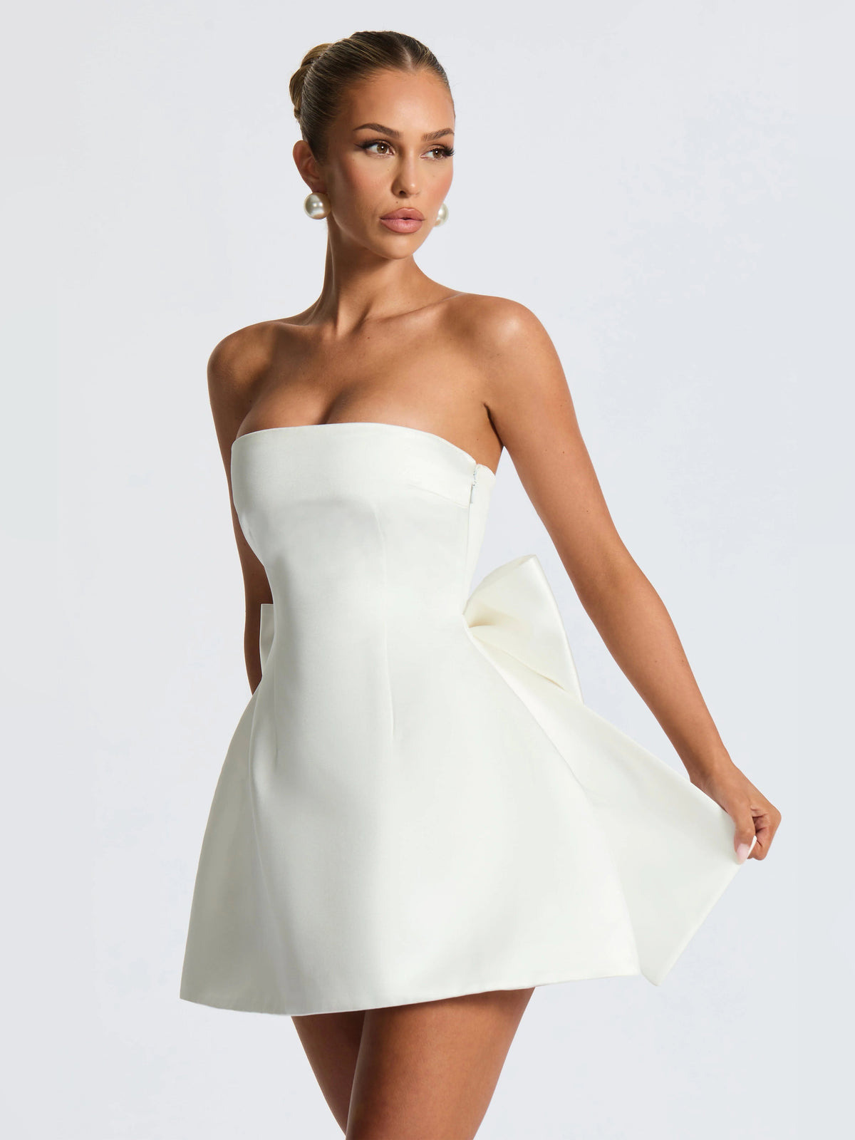 Ivory strapless mini dress with ruched waist detail and side drape, 3/4 view.