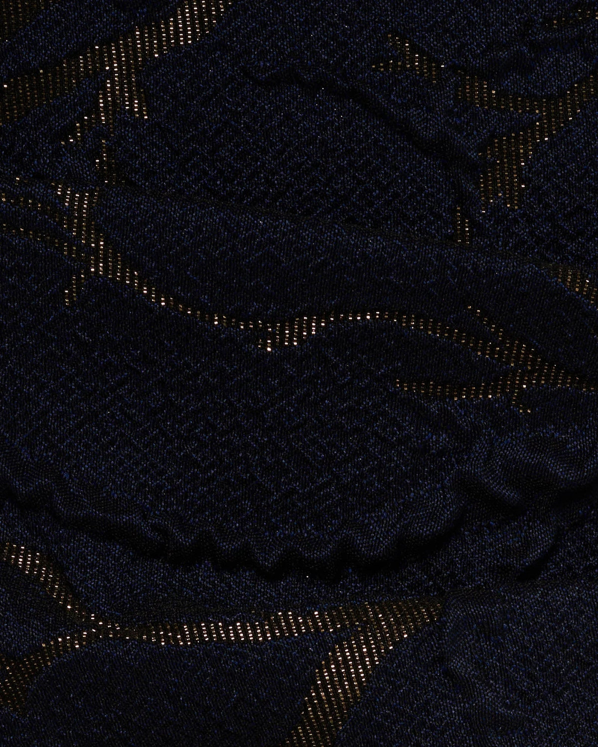Navy fabric close-up with shimmering gold abstract pattern