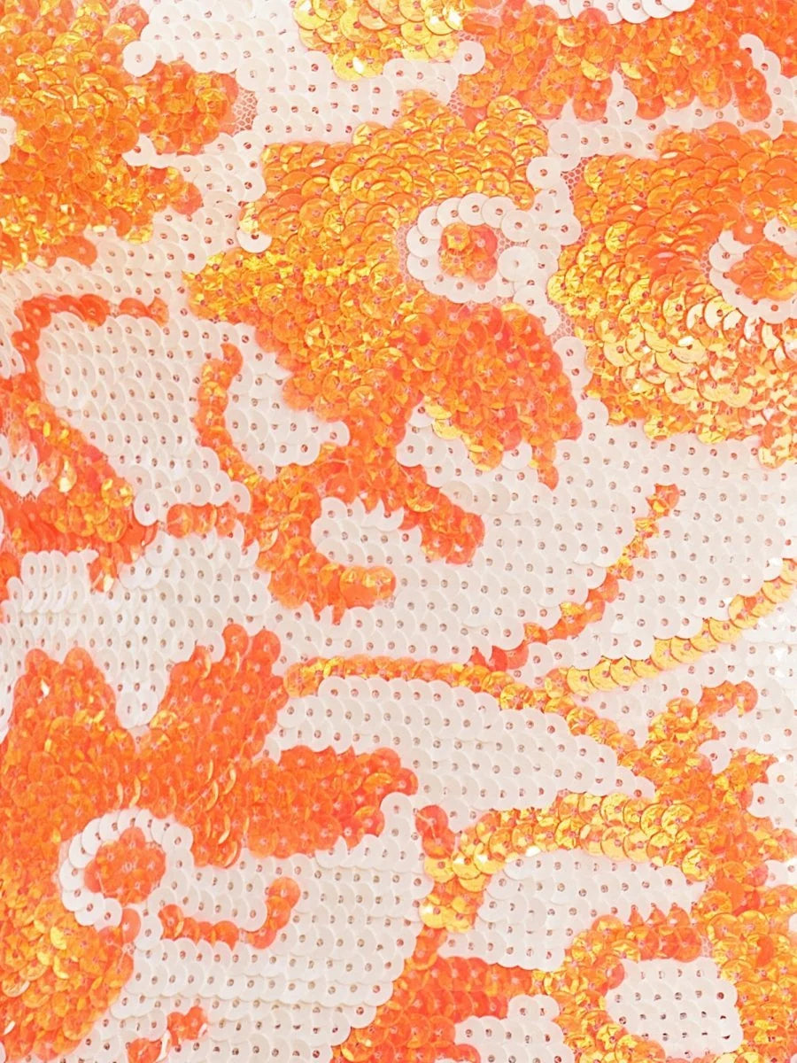 Orange and white sequin floral fabric close-up with shimmering pattern