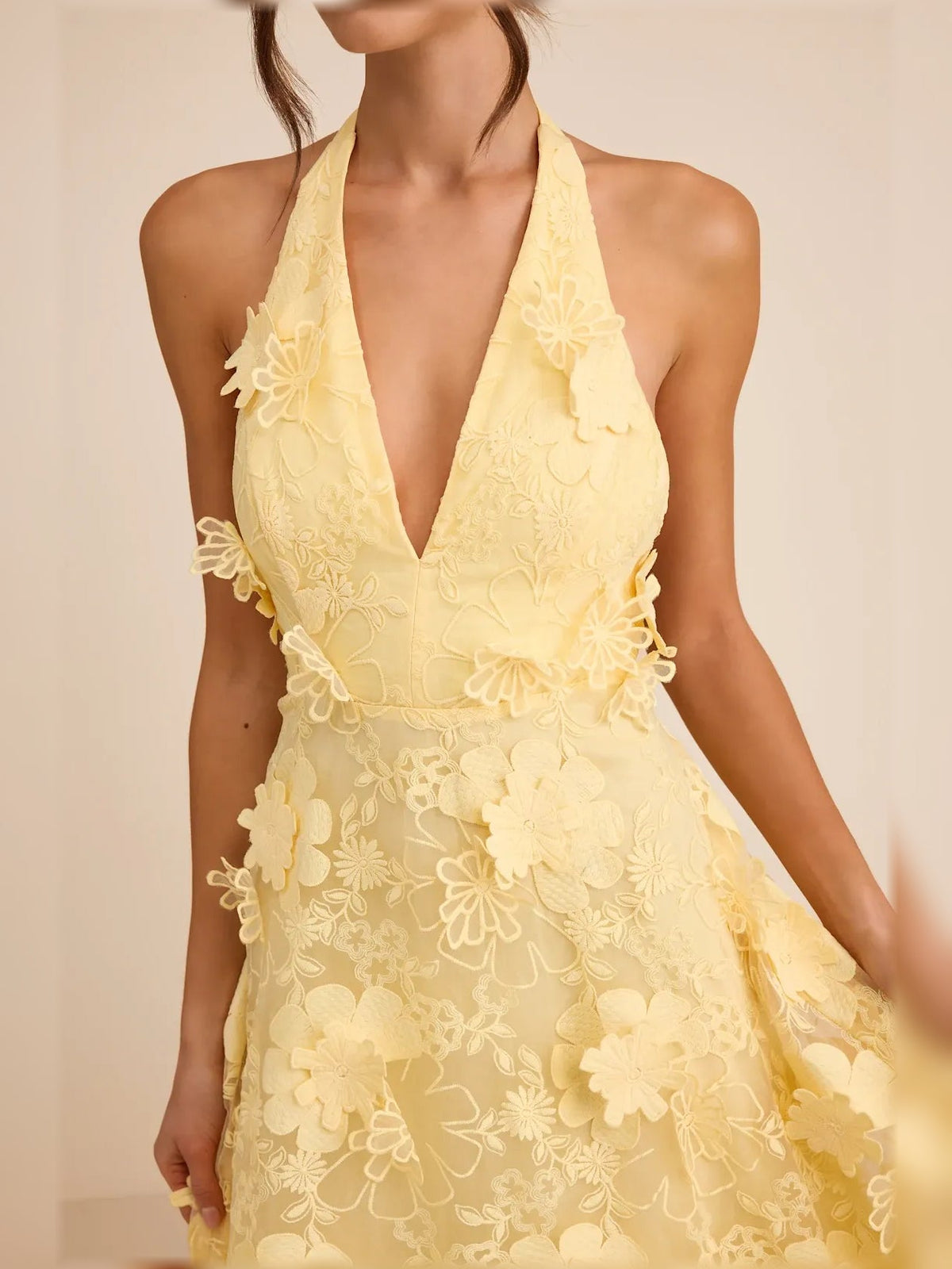 Yellow halter neck dress with floral lace appliques and deep V neckline close-up
