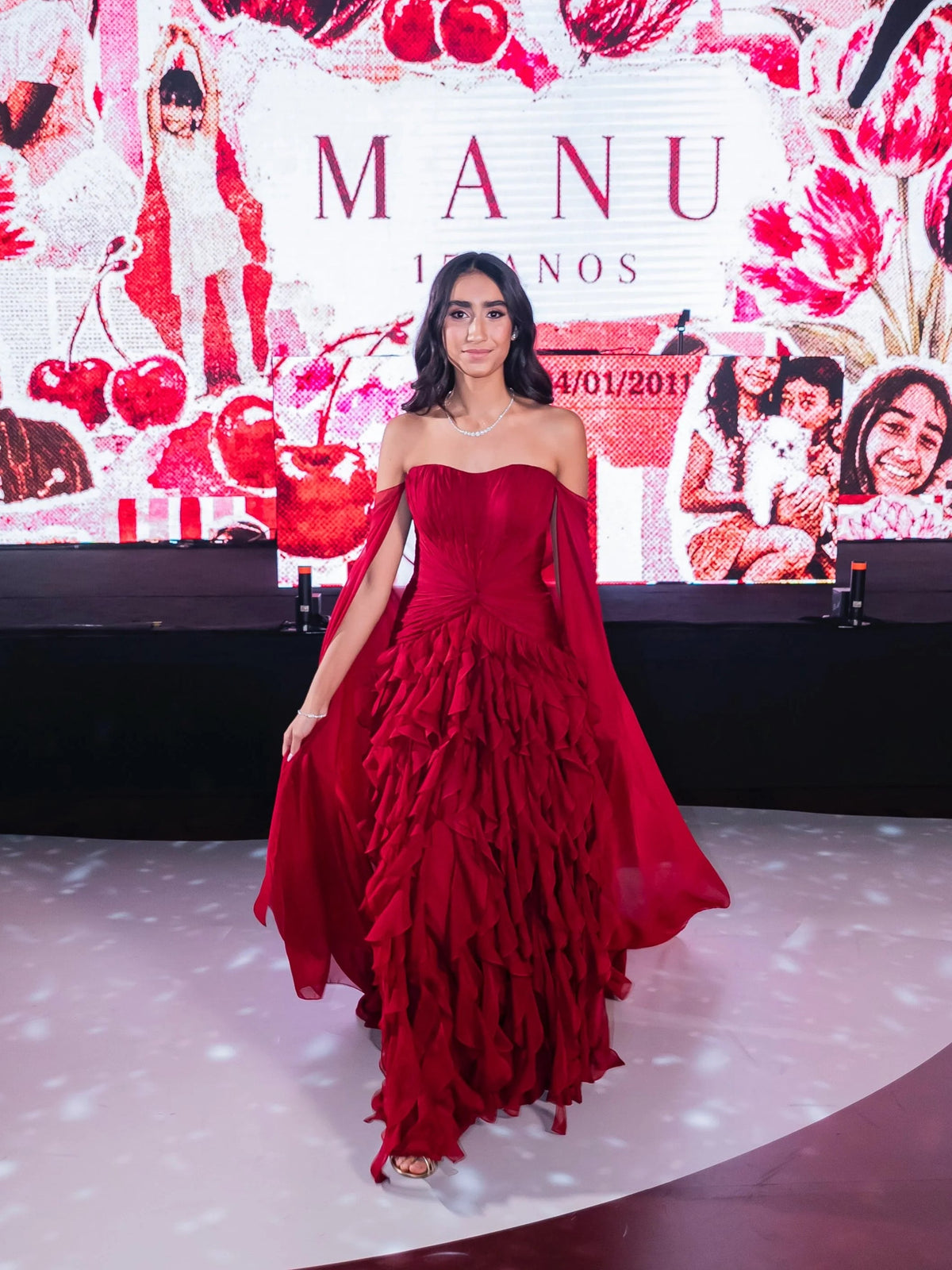 Red strapless sweetheart ball gown with ruched bodice and layered ruffle skirt, event pose
