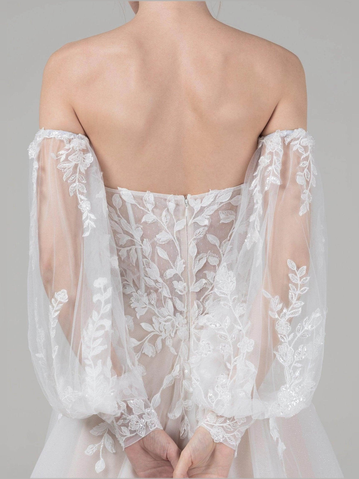 Ivory lace back bodice with off-shoulder sleeves on A-line wedding dress, close-up