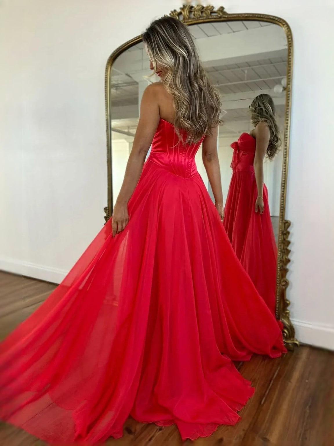 Red strapless corset A-line prom dress with bow bodice and full pleated skirt
