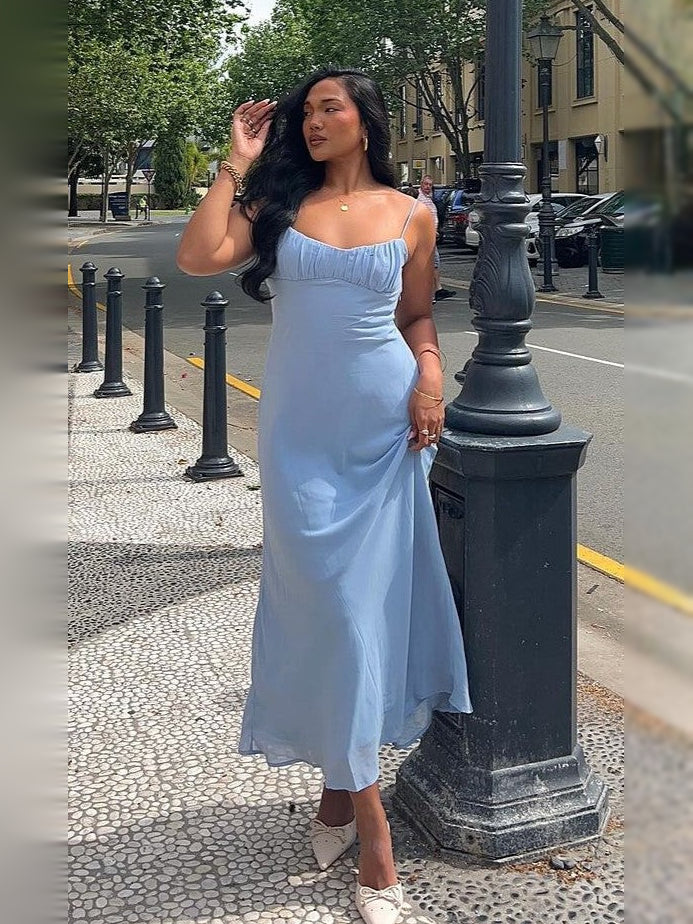 Light blue midi formal dress with ruched bust and thin straps, street side view