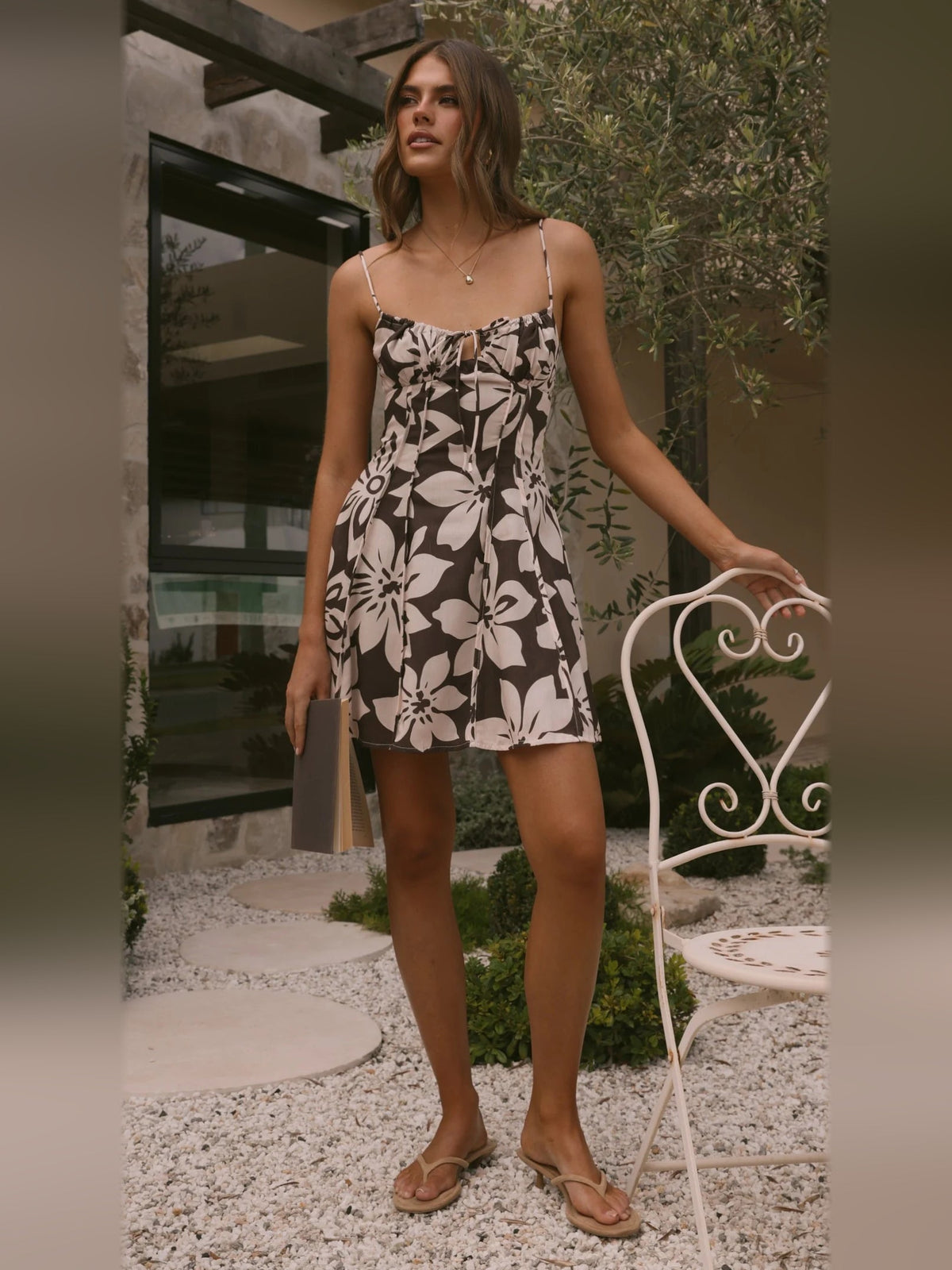 Chocolate floral mini dress viewed from side, with thin straps and flared hem