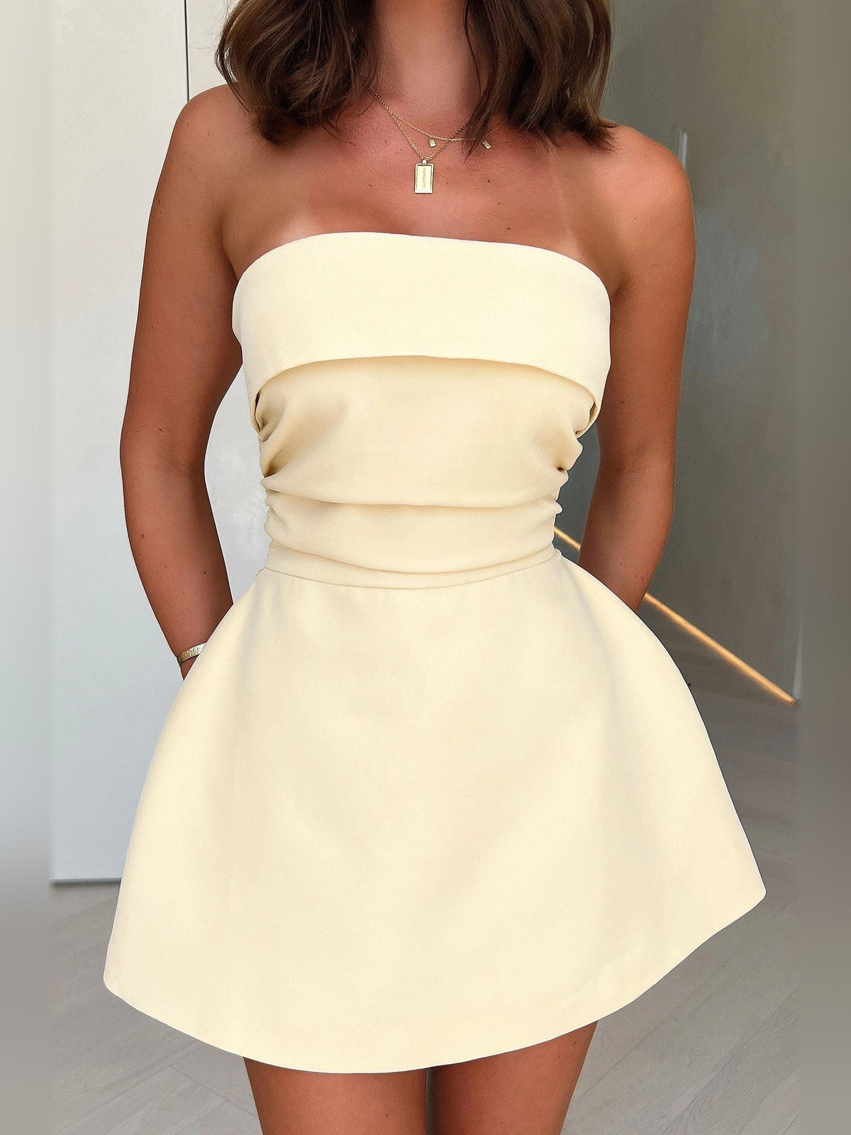 Pale lemon strapless A-line mini dress with gathered waist and flared skirt