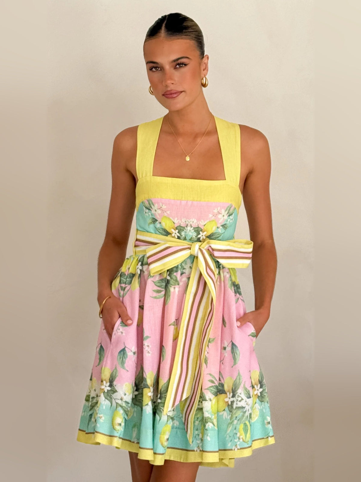 Pastel lemon print mini dress with square neckline, sleeveless bodice and striped bow-tie waist