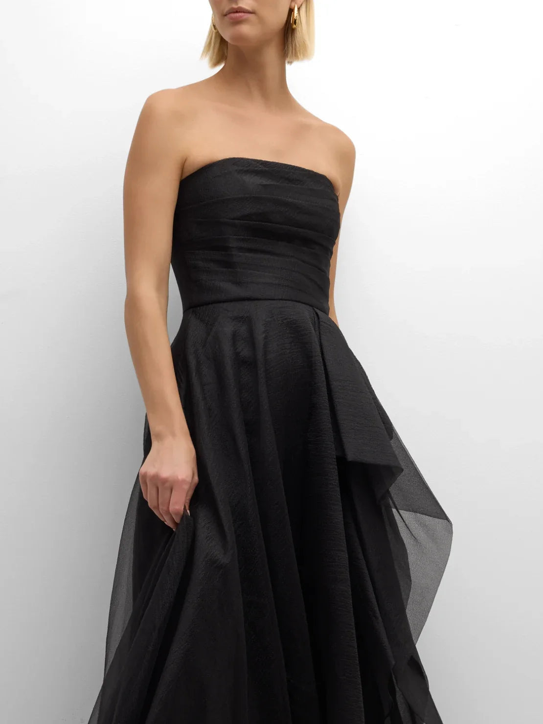 Black strapless ruffle A-line formal dress with tiered sheer overlay, side view.