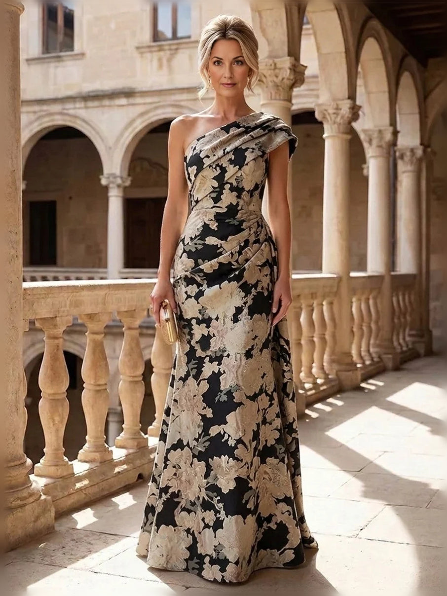 Black-and-cream floral one-shoulder mermaid gown with ruched drape, floor-length.