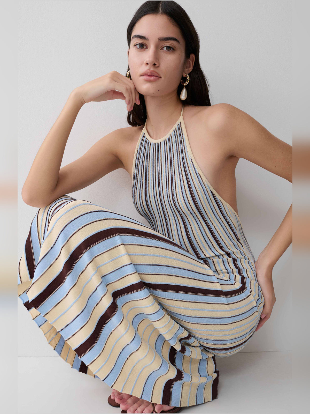 Halterneck knit midi dress worn with vertical cream, blue, and brown stripes; draped skirt.