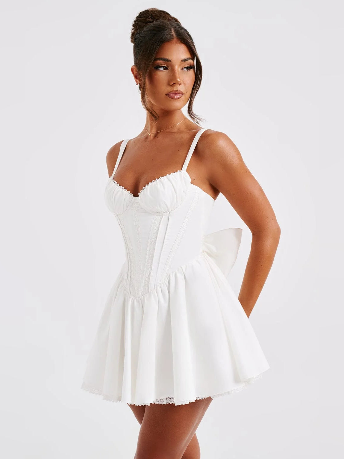 White mini homecoming dress with sweetheart neckline, ruched bodice, and flared skirt