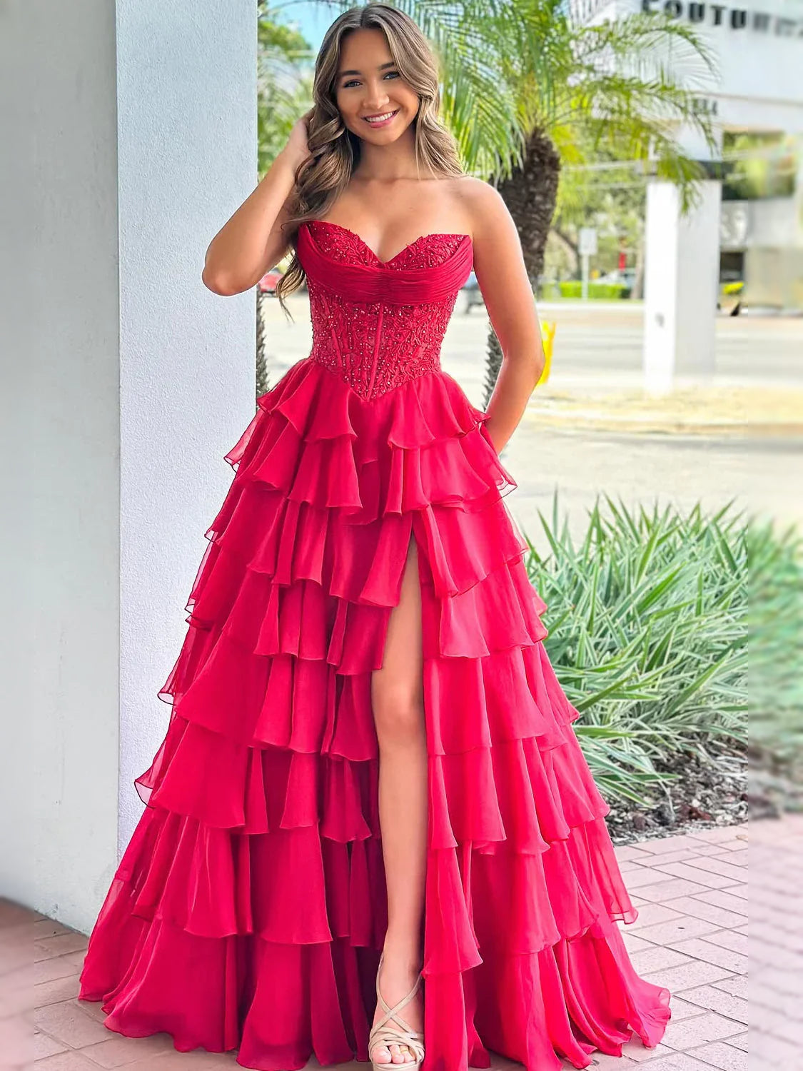 Red strapless corset prom dress with tiered ruffle skirt and side slit, long high-low hem