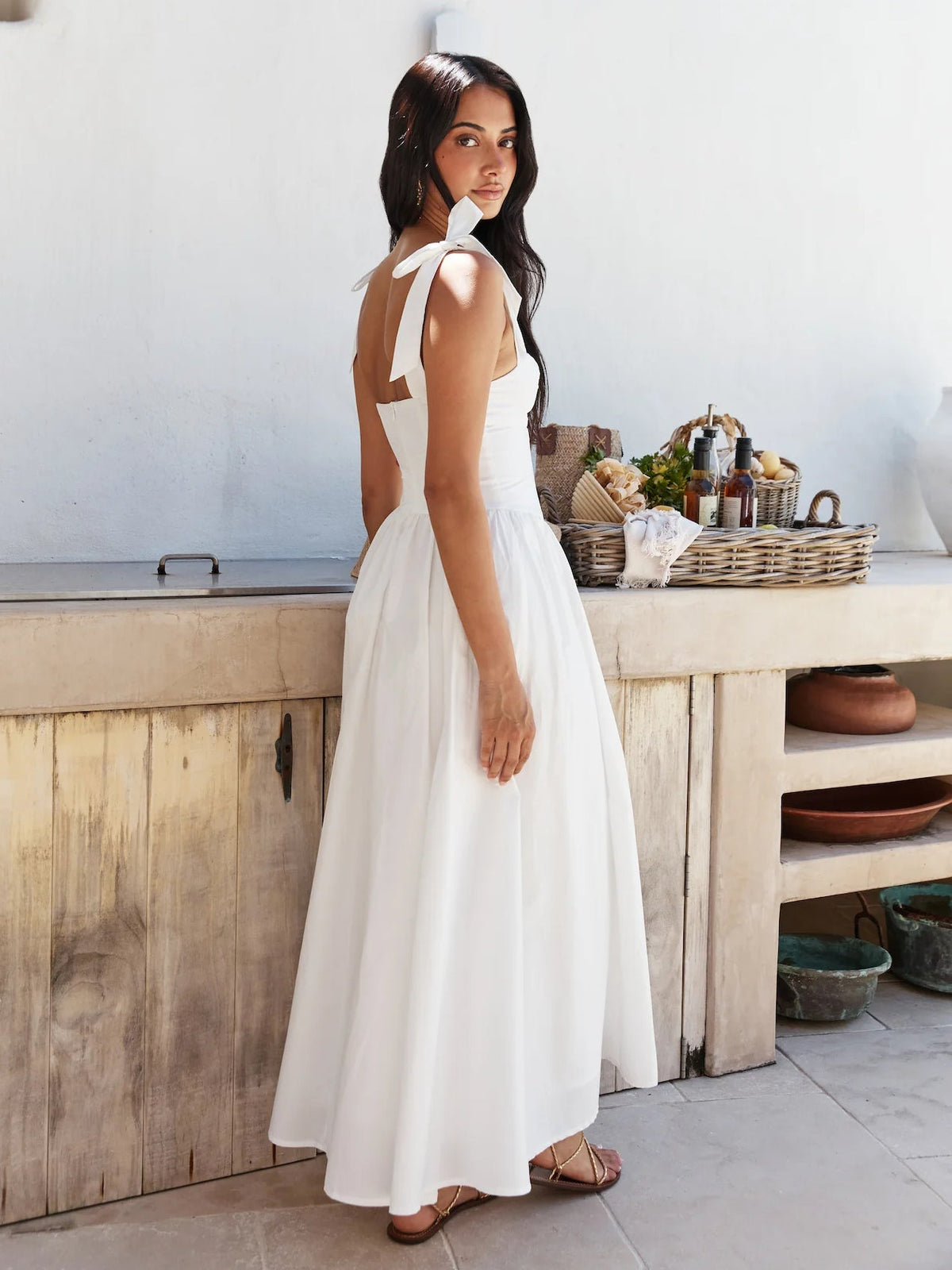 White midi formal dress, side view with bow straps, fitted bodice, and gathered skirt.