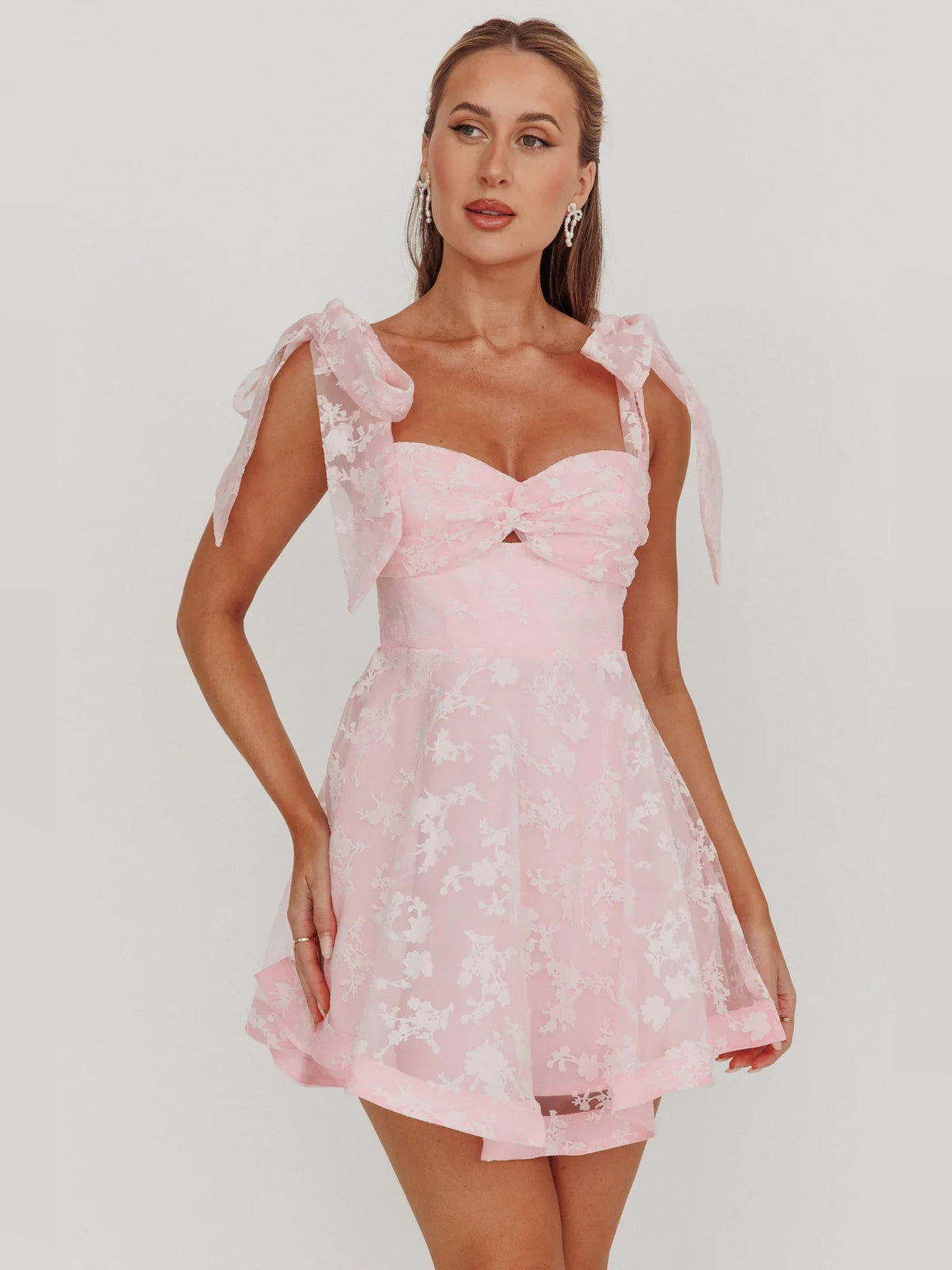 Blush pink sweetheart mini dress with bow shoulder sleeves and layered organza floral hem