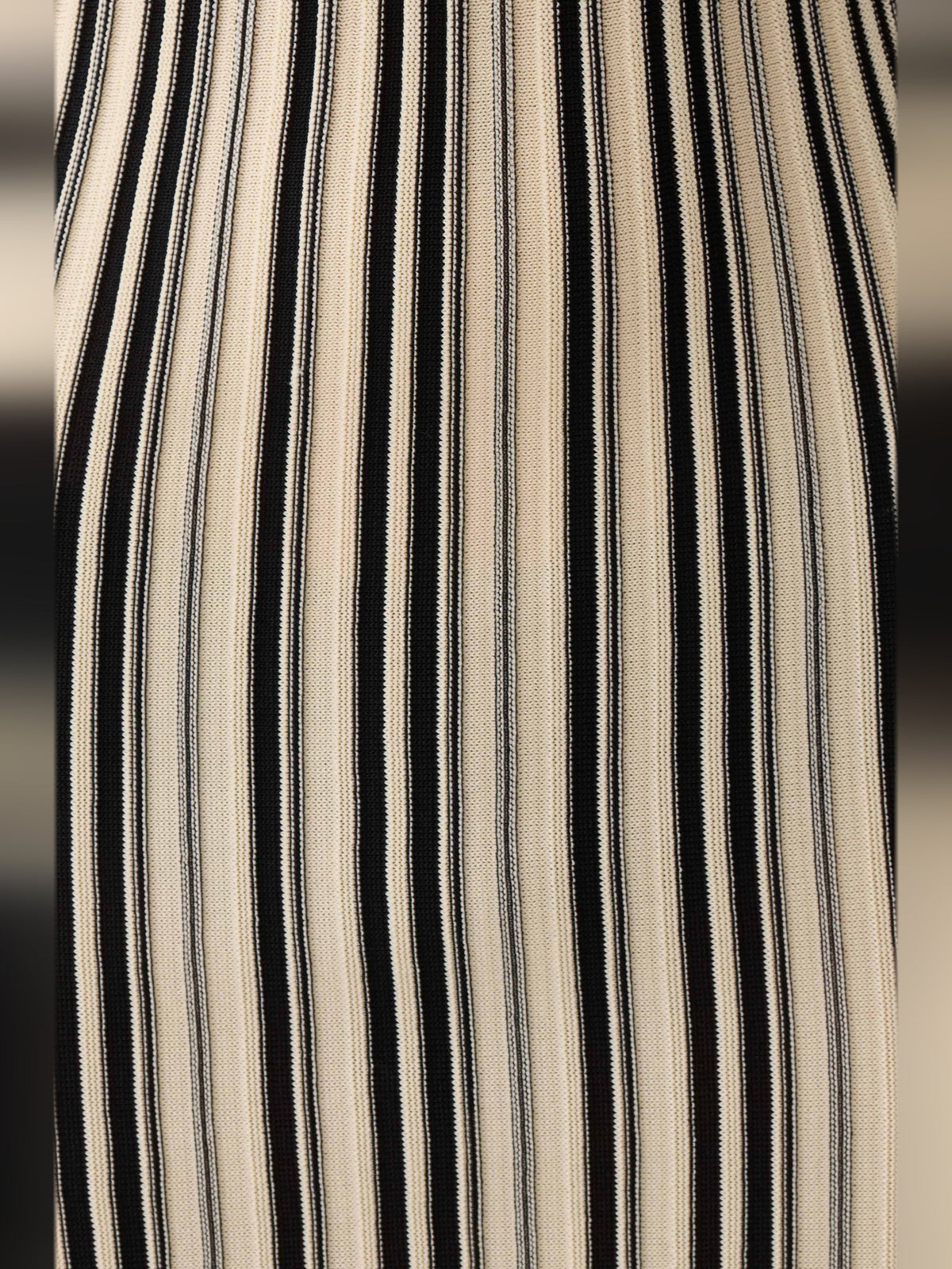 Close-up of vertical striped fabric in ivory with black and gold tones