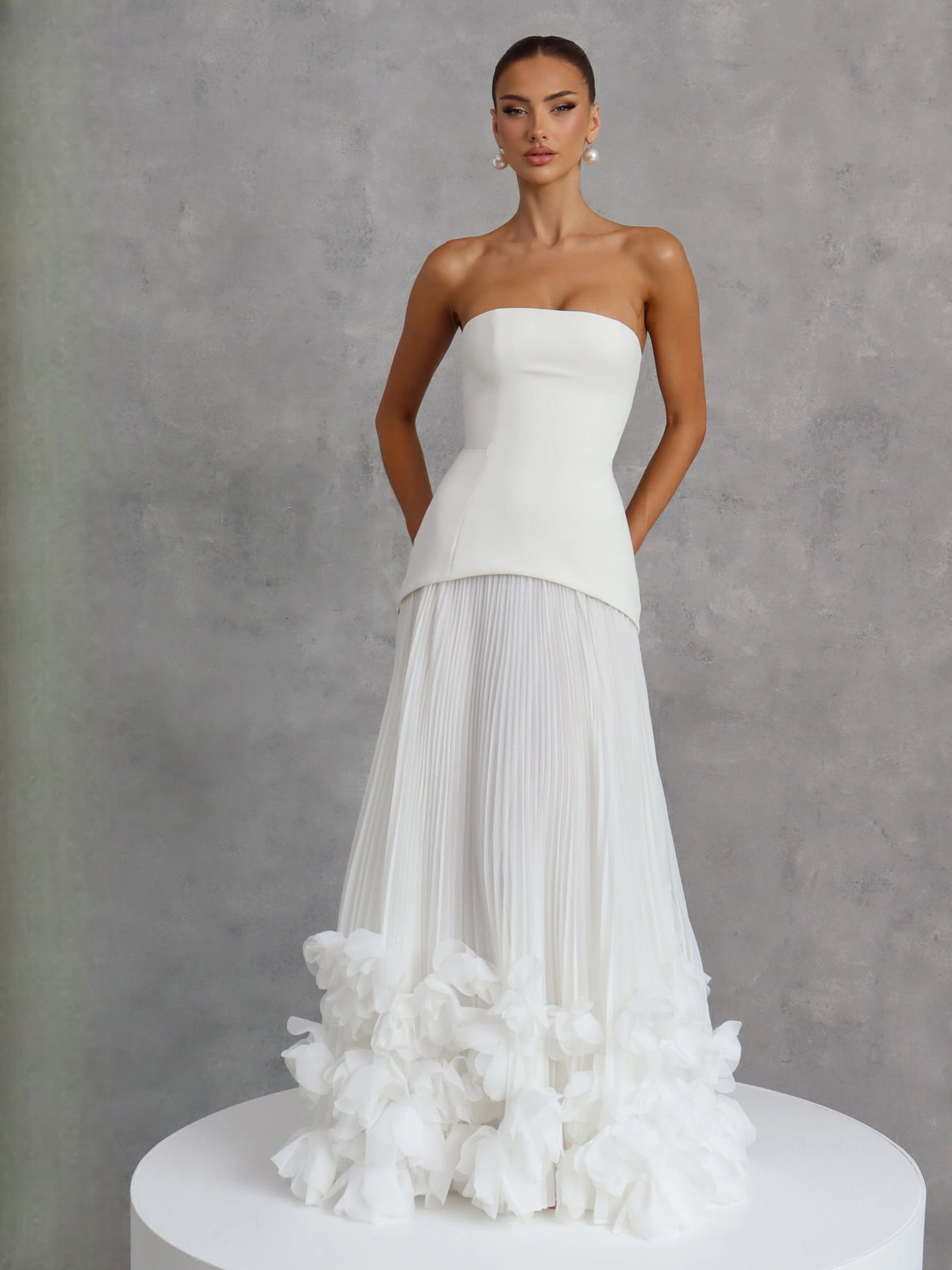 Ivory strapless wedding dress on display with corset bodice and fluffy layered floral hem