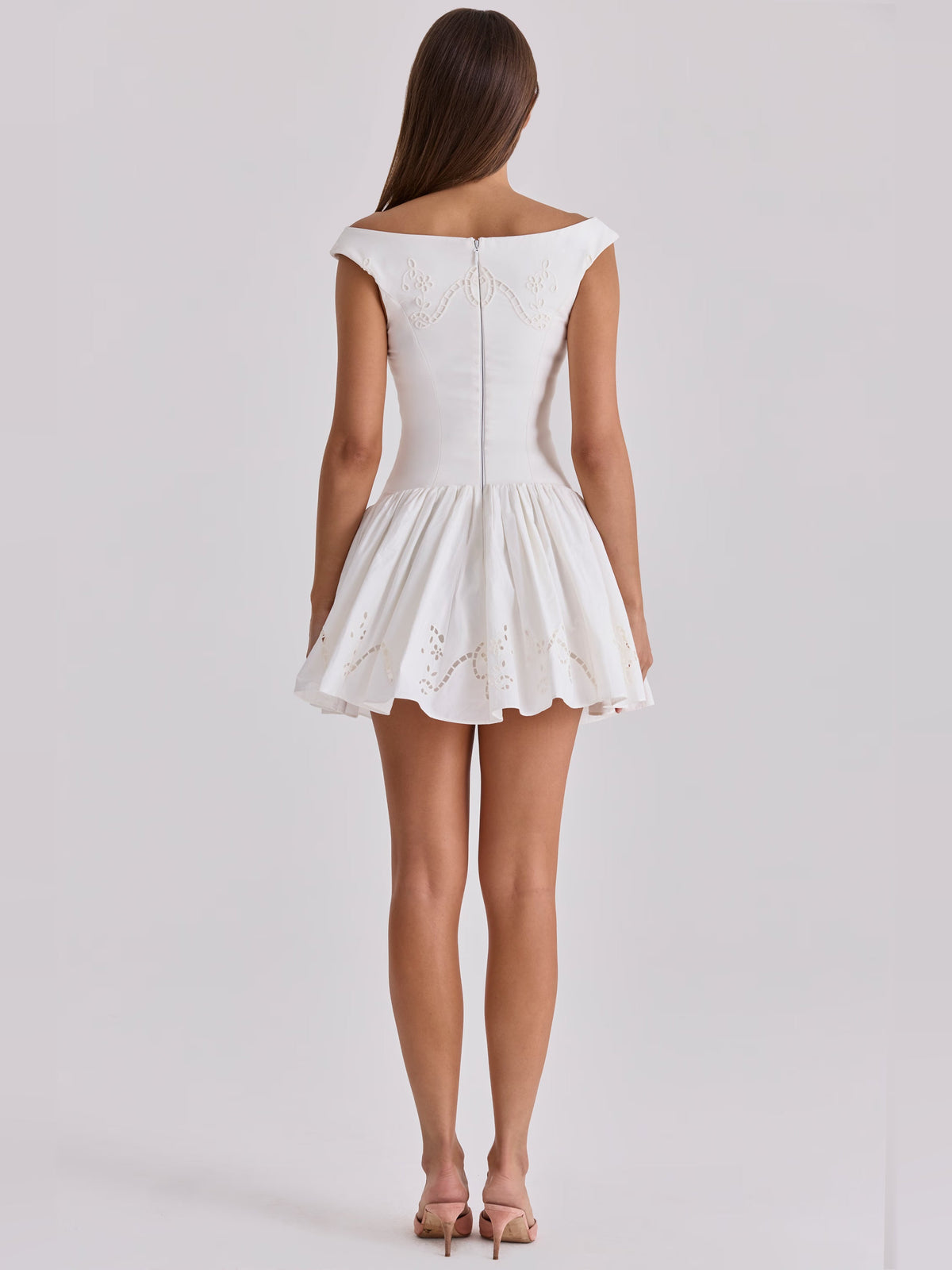 White boat-neck mini dress, back view showing embroidered waist seam and flared skirt