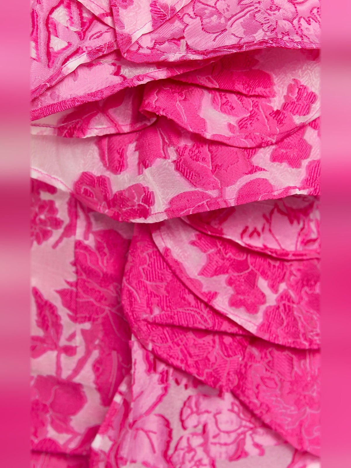 Close-up of hot pink floral print fabric with layered ruffles