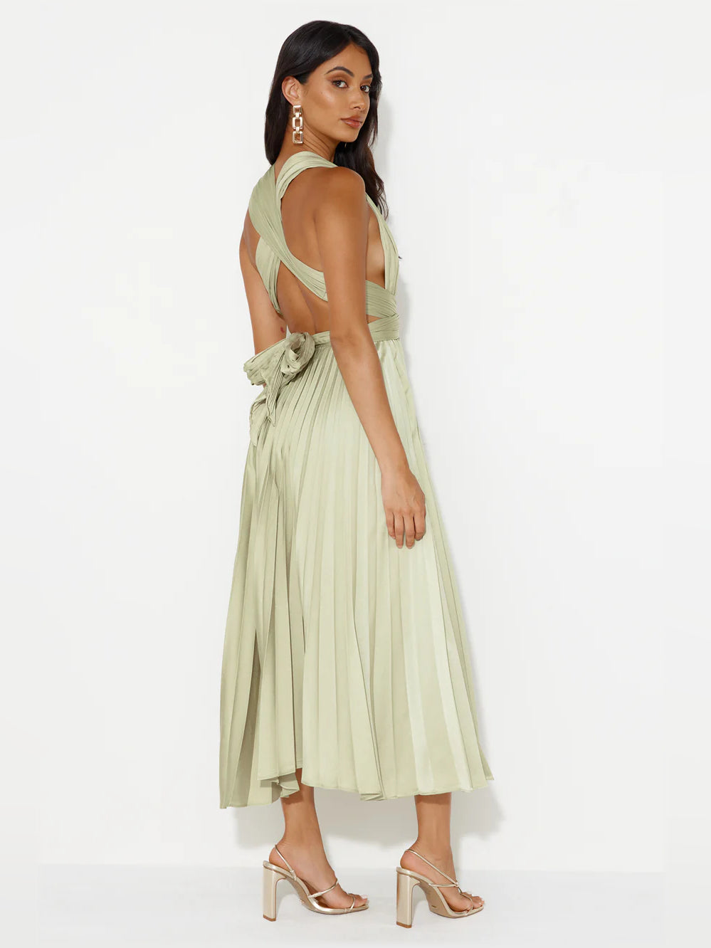 Side view of champagne midi formal dress with crisscross back straps and pleated skirt