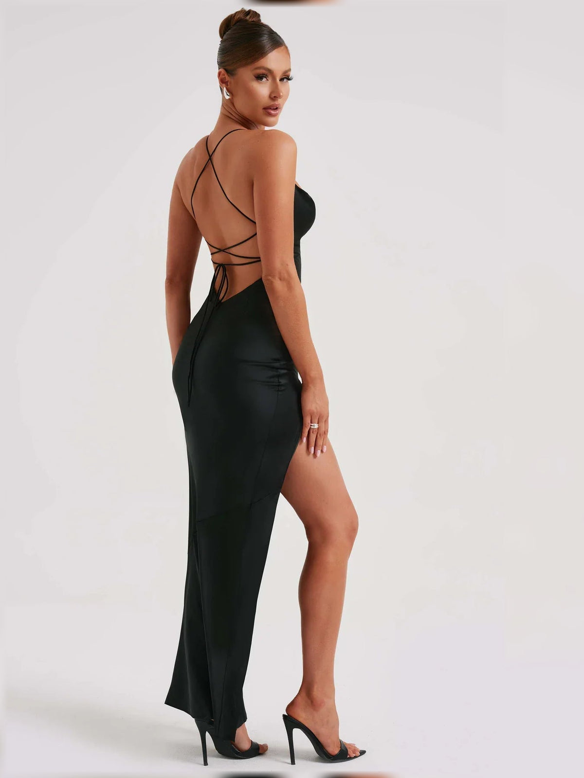 Black satin formal dress with open back crisscross straps and high side slit