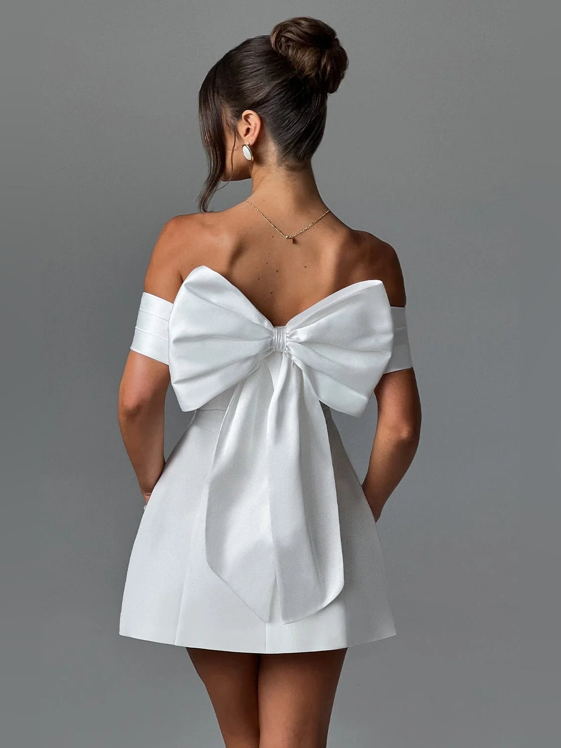 White off-shoulder A-line mini satin dress with large back bow detail