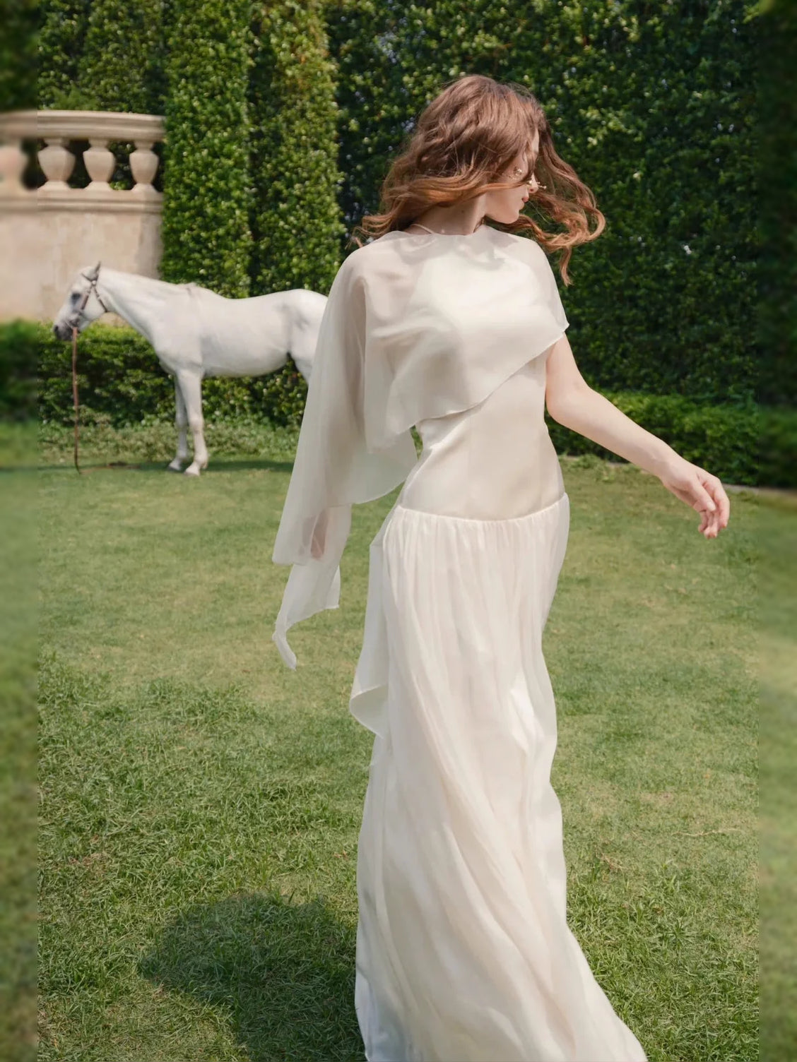 Ivory chiffon halter A-line gown with flowing back drape and long trailing skirt