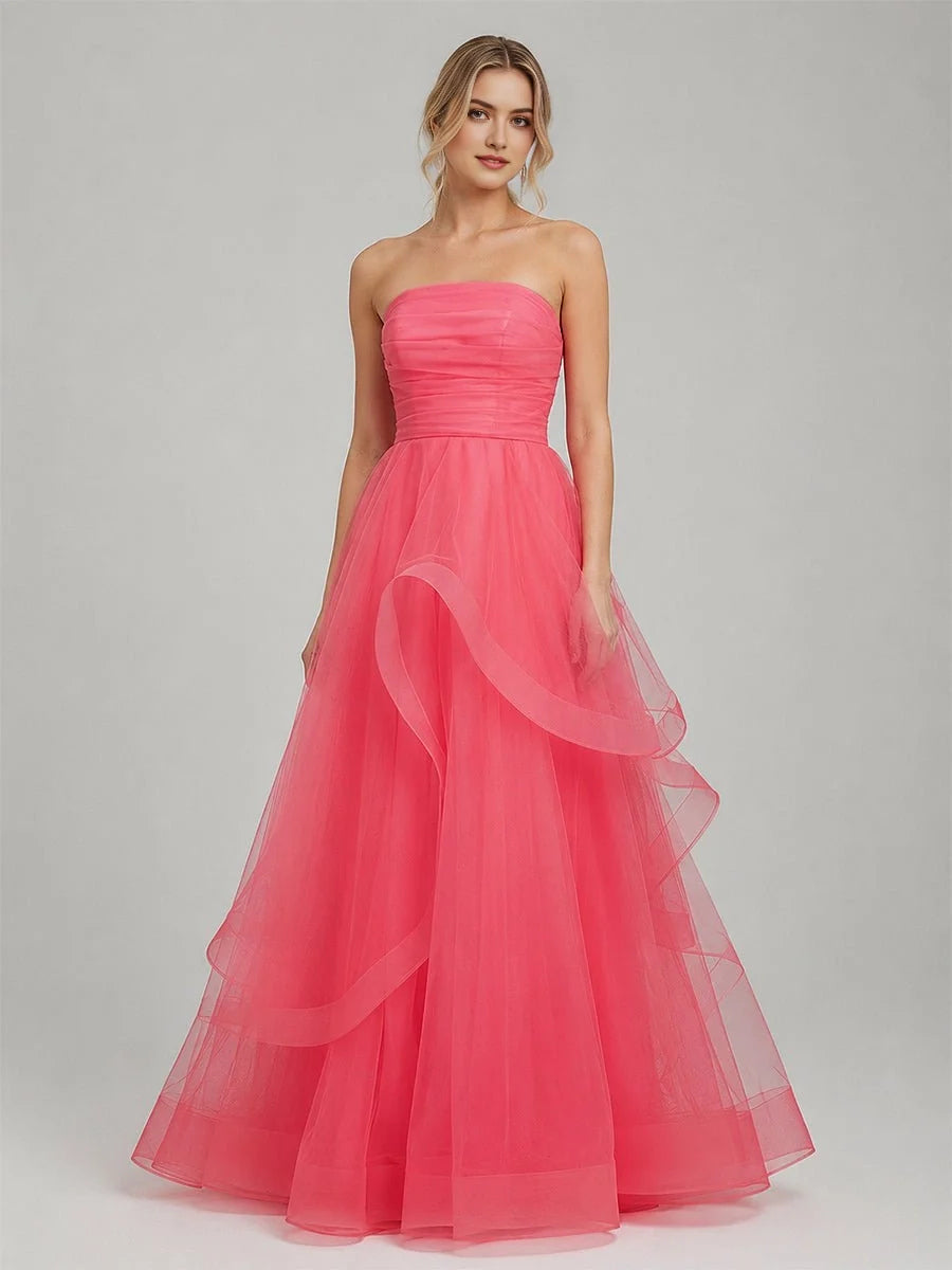 Light pink strapless tulle prom dress with ruched bodice and cascading ruffle overlays