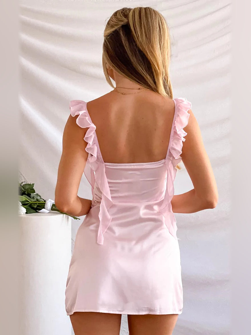 Pink satin mini dress with open back and ruffled shoulder straps, rear view