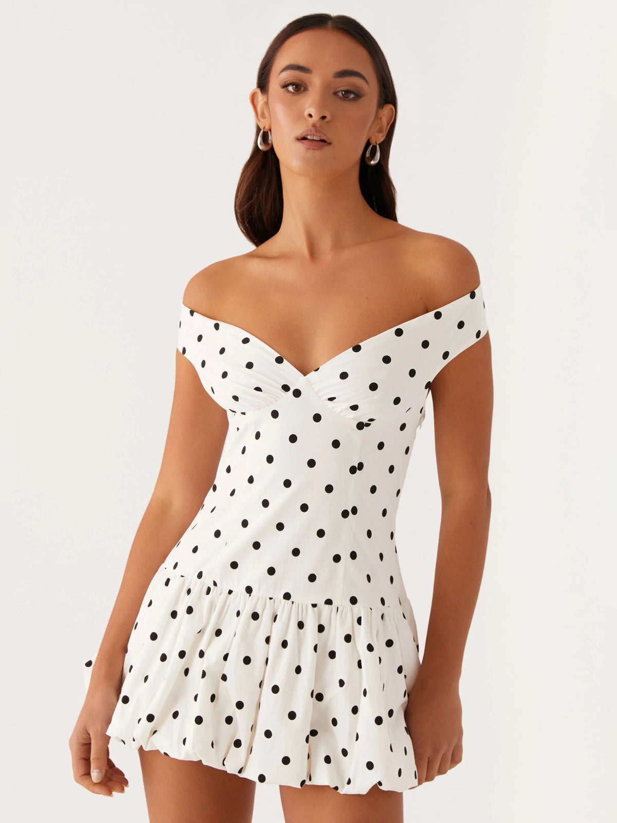 Off-shoulder mini dress in white with black polka dots, fitted bodice, short flared skirt