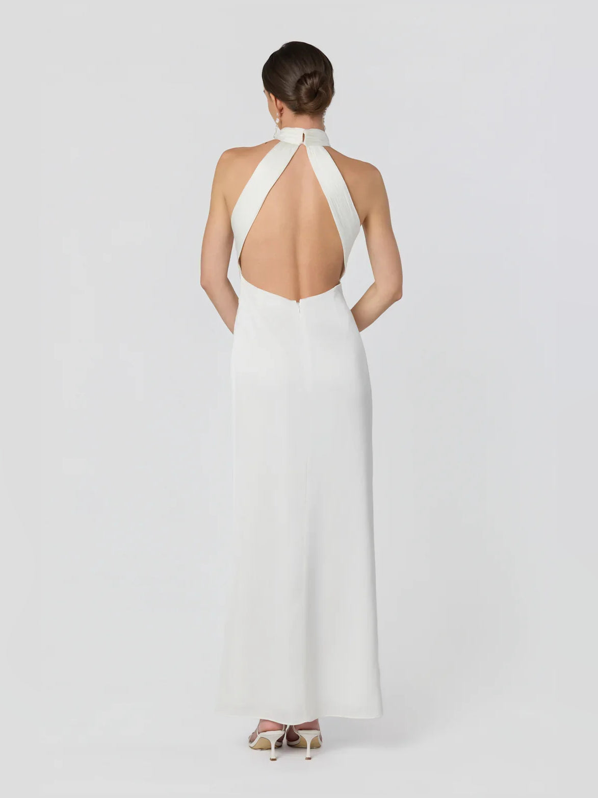 White halter neck formal dress with open back and long fitted silhouette