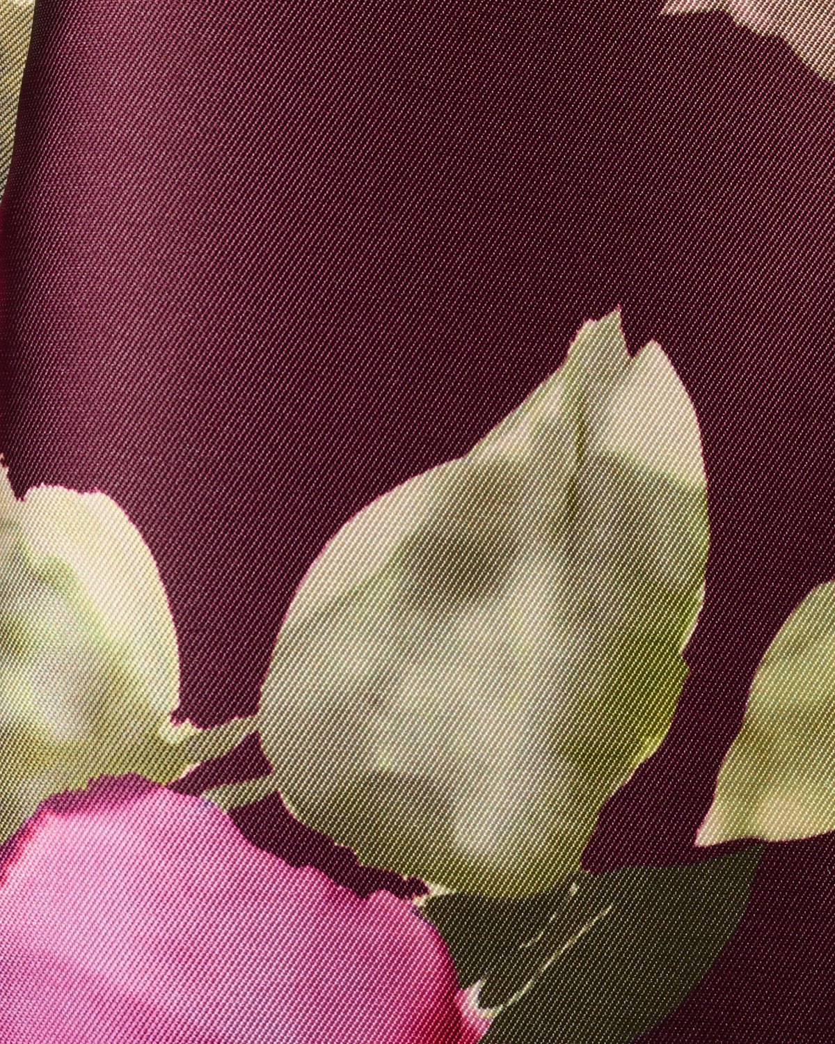 Close-up of burgundy floral fabric with pink, green, and cream flower prints