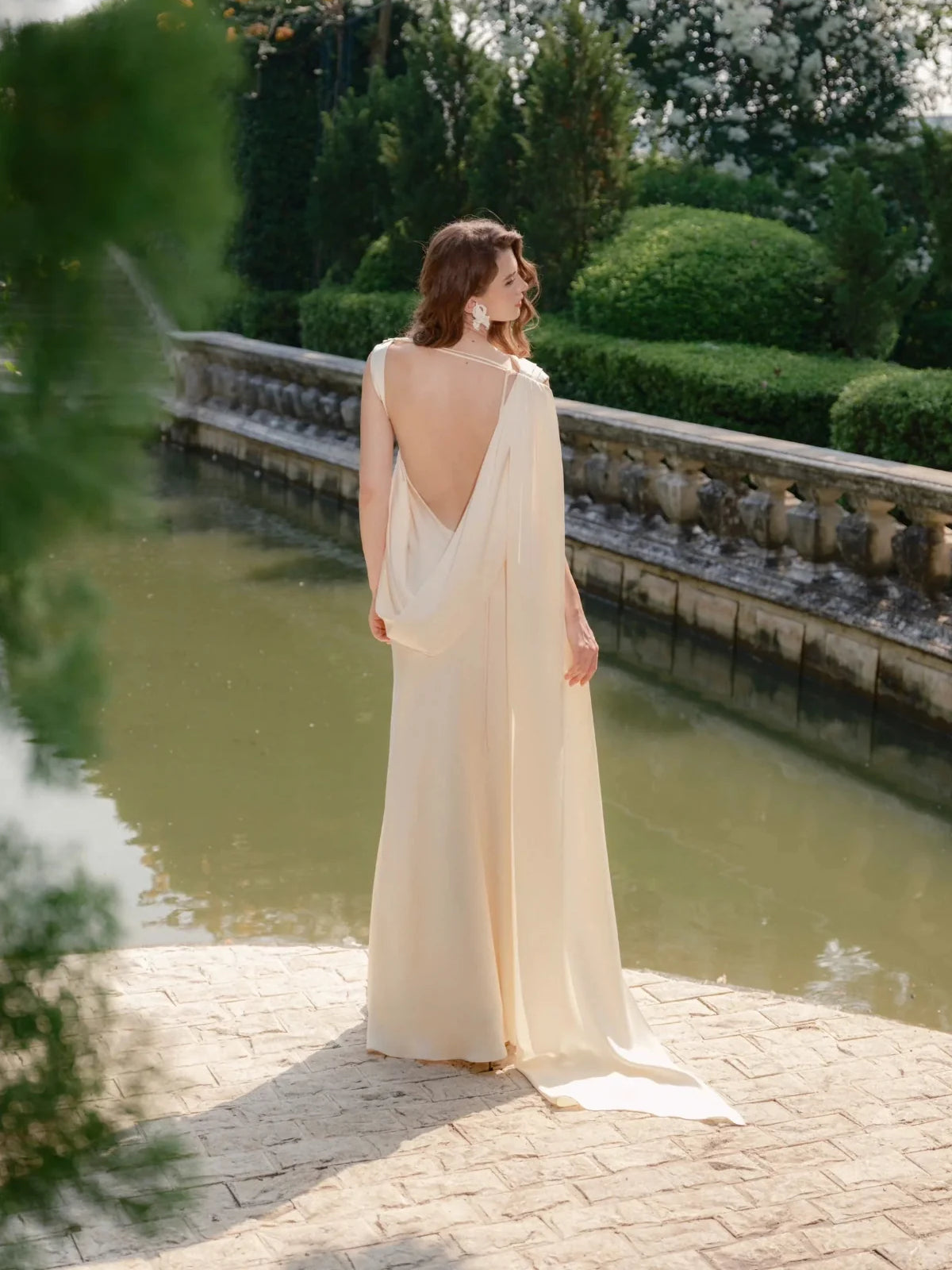 Ivory satin floor-length sheath wedding dress, back view with soft draped fabric